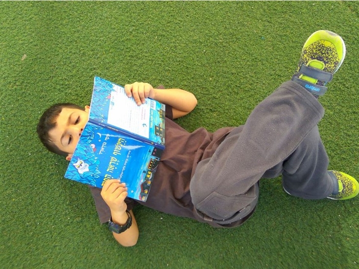 A boy enjoying his new book The Backward Owl, in Ramat Kramim school in Ashkelon